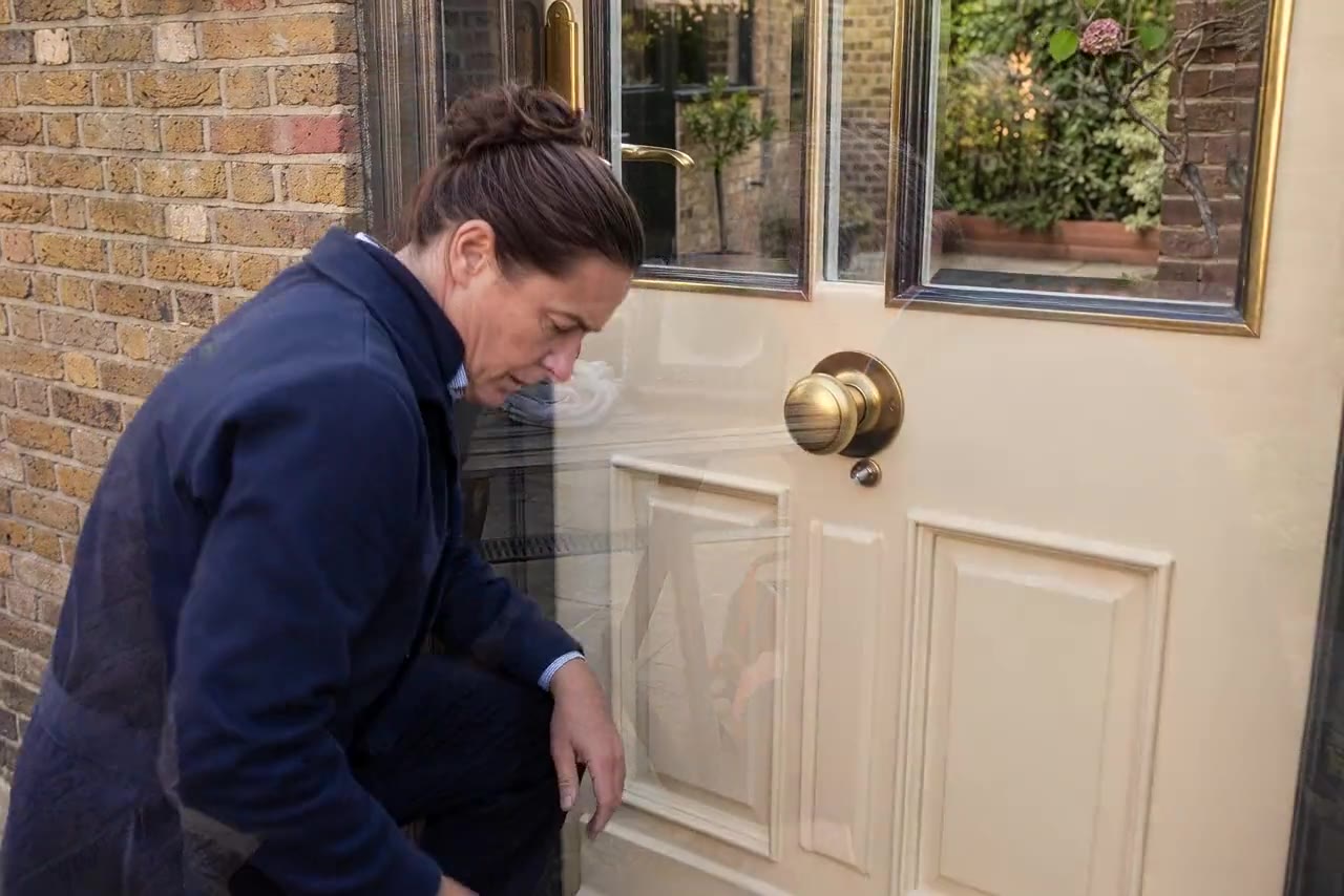 A locksmith fitting a new lock to a London front door