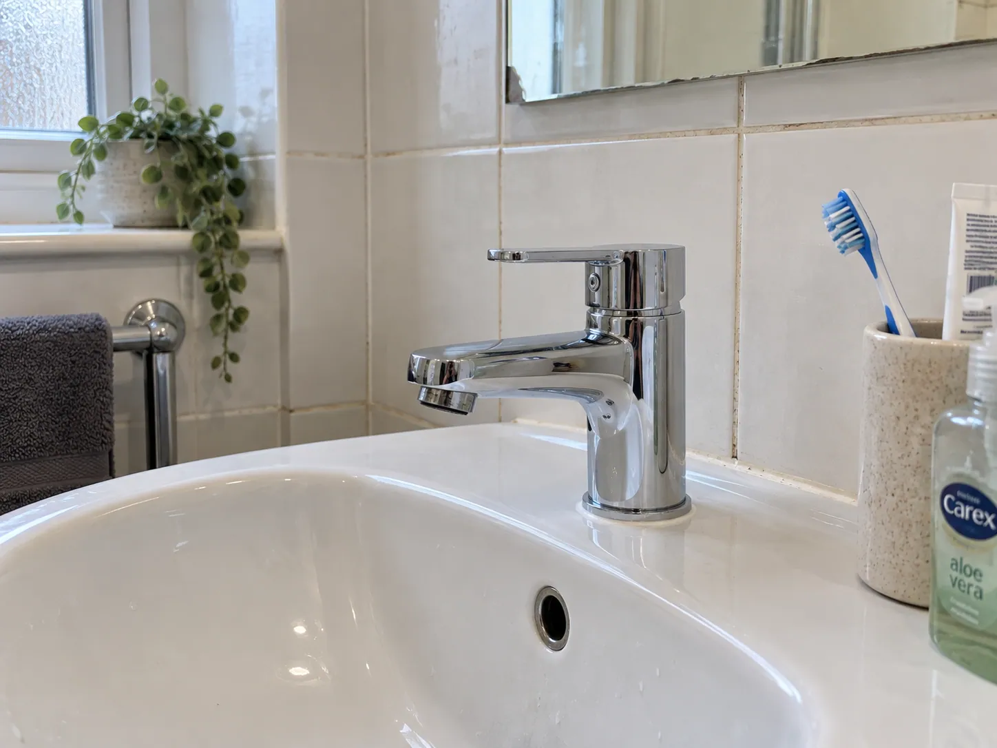 AI-generated illustration: Chrome mixer tap on a bathroom basin