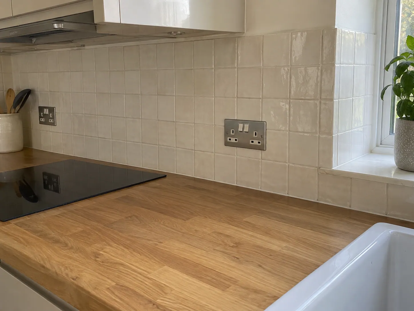 AI-generated illustration: Neutral painted kitchen wall above a tiled splashback