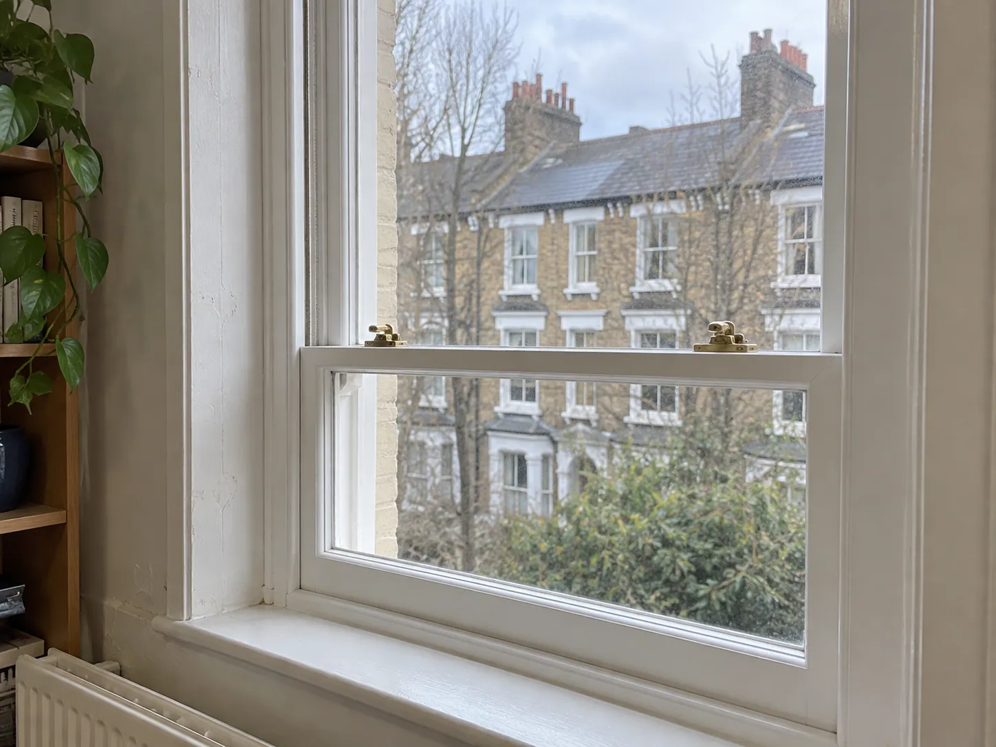 AI-generated illustration: Timber sash window overlooking London terraces