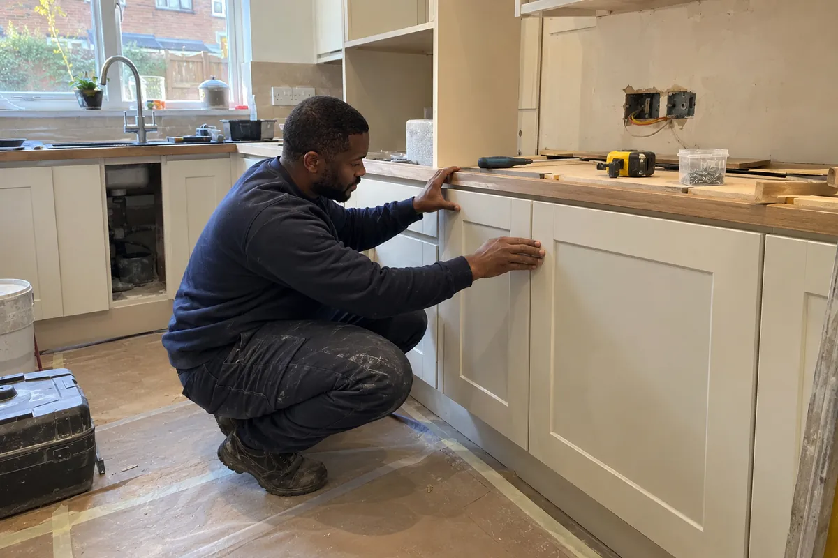 Kitchen units fitted and levelled, the worktop scribed to the wall
