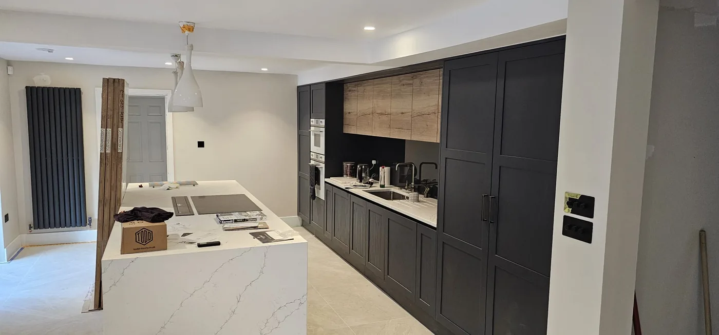 Kitchen and island: Shaker units to the ceiling, a quartz island and the radiator set in.
