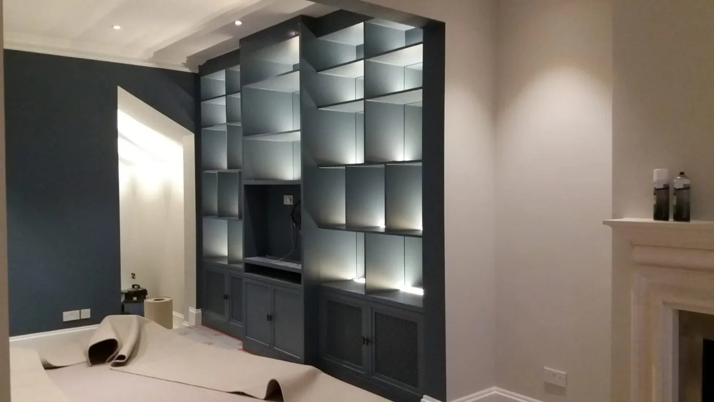 Built-in lit shelving fitted and painted in a London living room